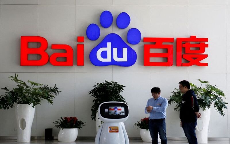 Baidu claims their new AI outperformed ChatGPT. Men interact with a Baidu AI robot near the company logo at its headquarters in Beijing, China April 23, 2021. REUTERS/Florence Lo