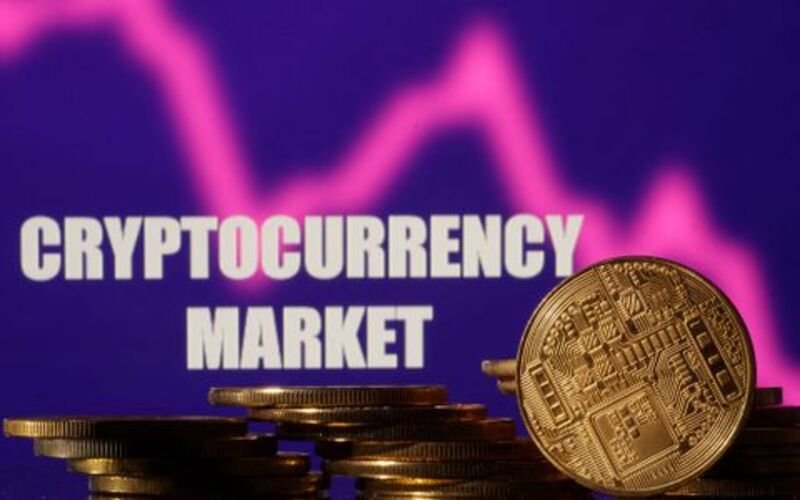 Representations of cryptocurrencies are seen in front of displayed words "Cryptocurrency market" and decreasing stock graph in this illustration