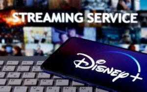 A smartphone with displayed "Disney" logo is seen on the keyboard in front of displayed "Streaming service" words in this illustration taken March 24, 2020. REUTERS/Dado Ruvic