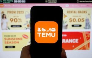 The logo of Temu, an e-commerce platform owned by PDD Holdings, is seen on a mobile phone displayed in front of its website, in this illustration picture taken April 26, 2023. REUTERS/Florence Lo/Illustration/File Photo