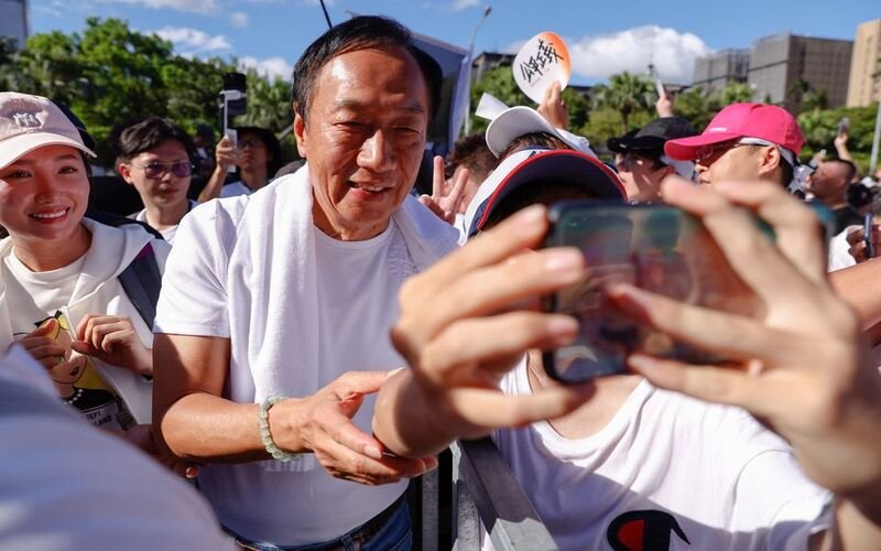 Supporters take a selfie with Terry Gou, the retired founder of major Apple supplier Foxconn