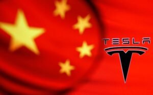 Chinese flag and Tesla logo is seen through a magnifier in this illustration taken January 7, 2021. REUTERS/Dado Ruvic/Illustration/File Photo