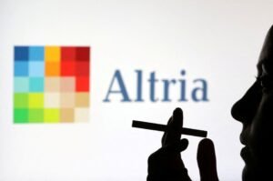 A woman poses with a cigarette in front of Altria logo in this illustration taken July 26, 2022. REUTERS/Dado Ruvic/Illustration/File Photo