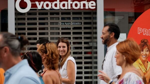 People walk past a Vodafone store in Ronda, Spain, October 3, 2022. REUTERS/Jon Nazca/File Photo