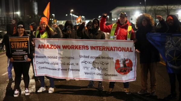People hold a banner during a Black Friday strike outside the Amazon warehouse, in Coventry, Britain November 24, 2023. REUTERS/Phil Noble