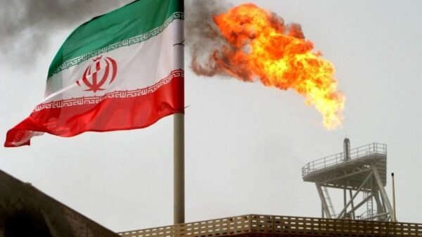 A gas flare on an oil production platform is seen alongside an Iranian flag in the Gulf July 25, 2005. REUTERS/Raheb Homavandi
