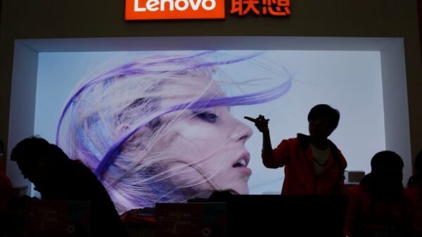 An employee gestures next to a Lenovo logo at Lenovo Tech World in Beijing, China November 15, 2019. REUTERS/Jason Lee/File Photo