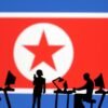 Miniatures of people with computers are seen in front of North Korea flag in this illustration taken July 19, 2023. REUTERS/Dado Ruvic/Illustration/File Photo