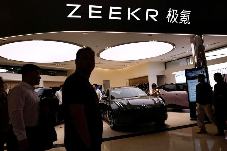 Exclusive: Geely’s Zeekr edges closer to a U.S. IPO, making its filing public this week. People walk past a booth of Zeekr, Chinese automaker Geely's premium electric vehicle (EV) brand, at a shopping mall in Beijing, China November 3, 2023. REUTERS/Tingshu Wang/File Photo