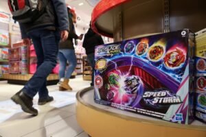 People walk past the Beyblade Burst Speedstorm, by Hasbro, Inc., on display in the FAO Schwarz toy store in Manhattan, New York City, U.S., November 24, 2021. REUTERS/Andrew Kelly/File Photo