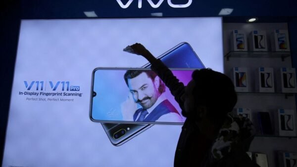 A man cleans a screen displaying a phone model of Chinese smartphone maker Vivo inside a shop in Ahmedabad, India, December 14, 2018 REUTERS/Amit Dave/File Photo