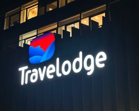 A lit-up Travelodge sign at night.A lit-up Travelodge sign at night.