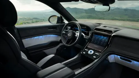 Bentley A black and silver car interior with views of countryside seen through the windows.